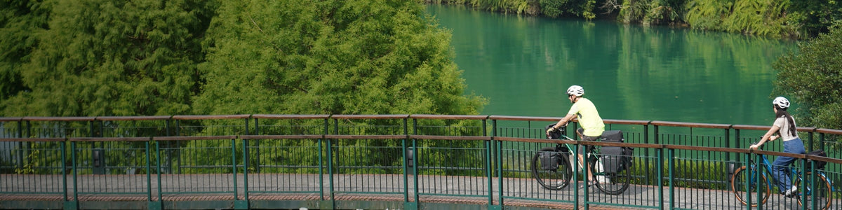 Cyclistes avec sacoches et porte-bagages Ibera sur une passerelle au bord d'un lac