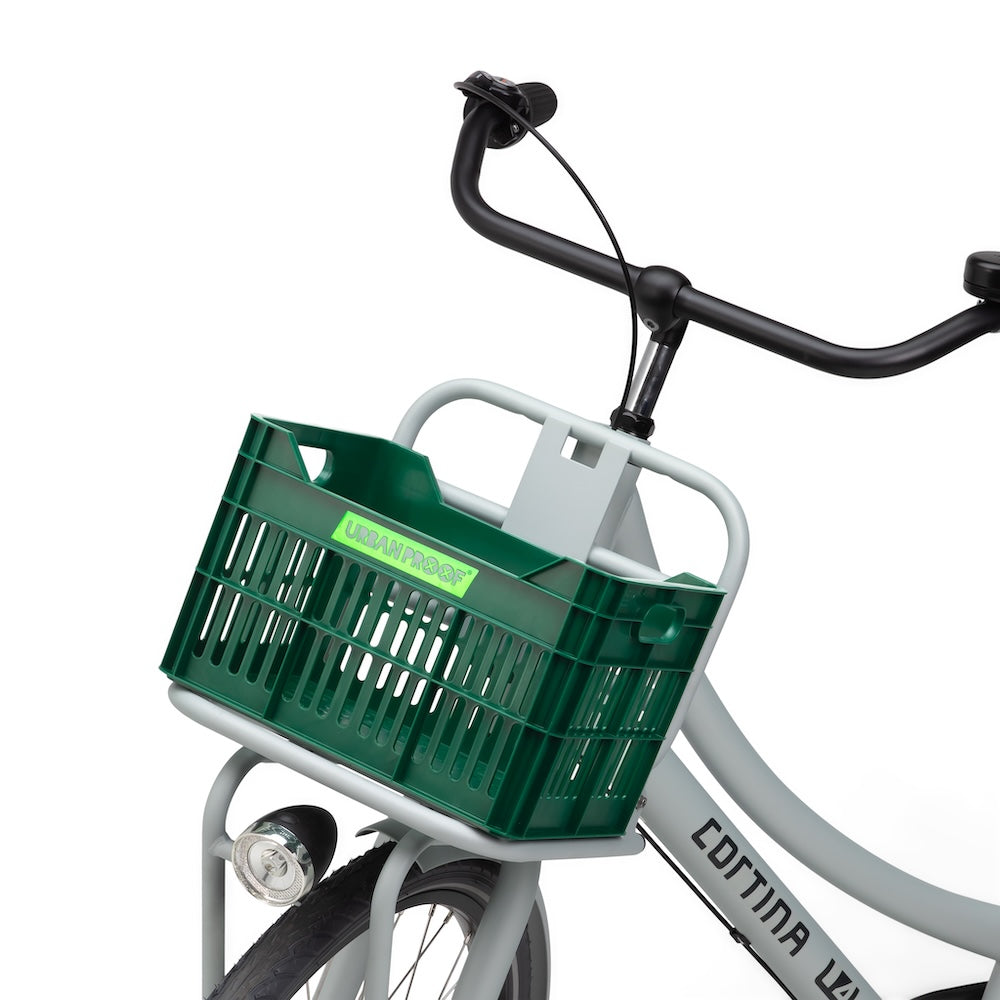 Caisse vélo enfant Urban Proof Junior 15L vert installée à l'avant d'un vélo d'enfant en situation urbaine