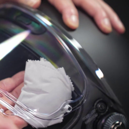 Lingette anti-buée VisioFog passée à l'intérieur d'une visière de casque