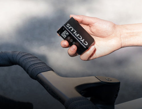 Mini pompe électrique vélo CYCPLUS AS2 Pro tenue au-dessus du guidon d'un vélo