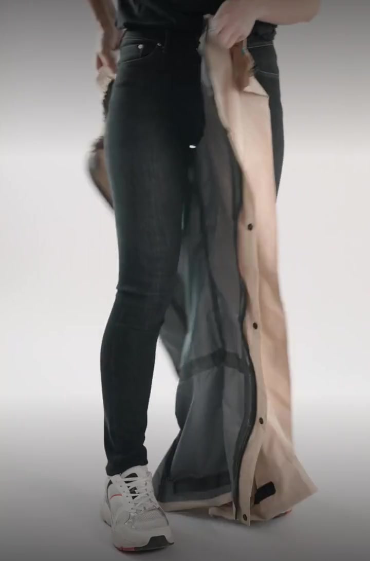 Enfiler le pantalon de pluie Hello Rain Premium grâce à ses zips latéraux