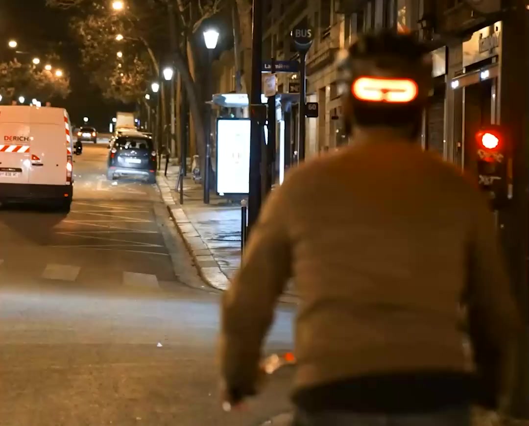 Éclairage clignotant Overade OxiTurn sur un casque, à vélo de nuit en ville