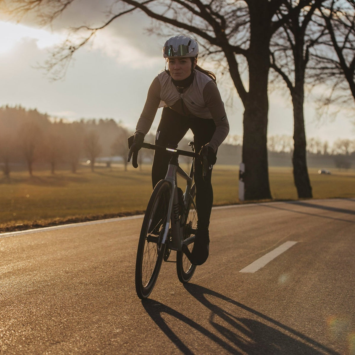 Cycliste sur une route au coucher du soleil, équipée d'un éclairage vélo Ravemen