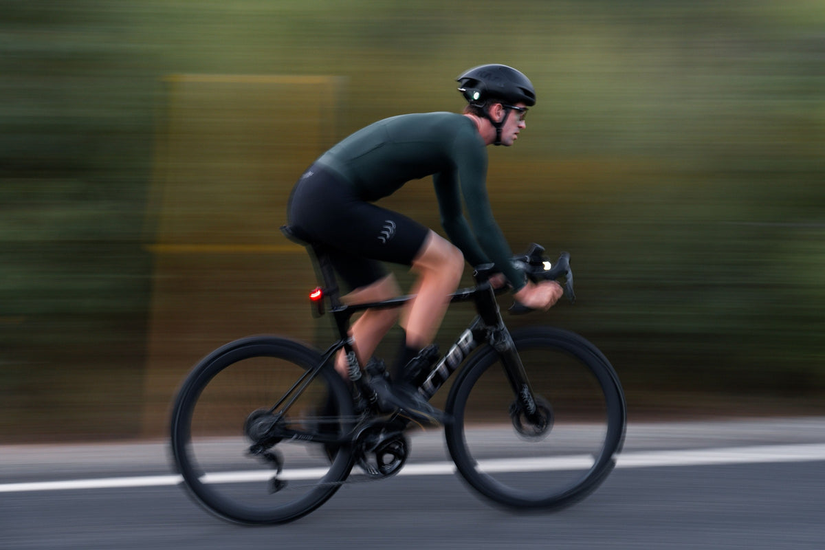 Cycliste sur route avec une lampe avant Ravemen allumée au guidon