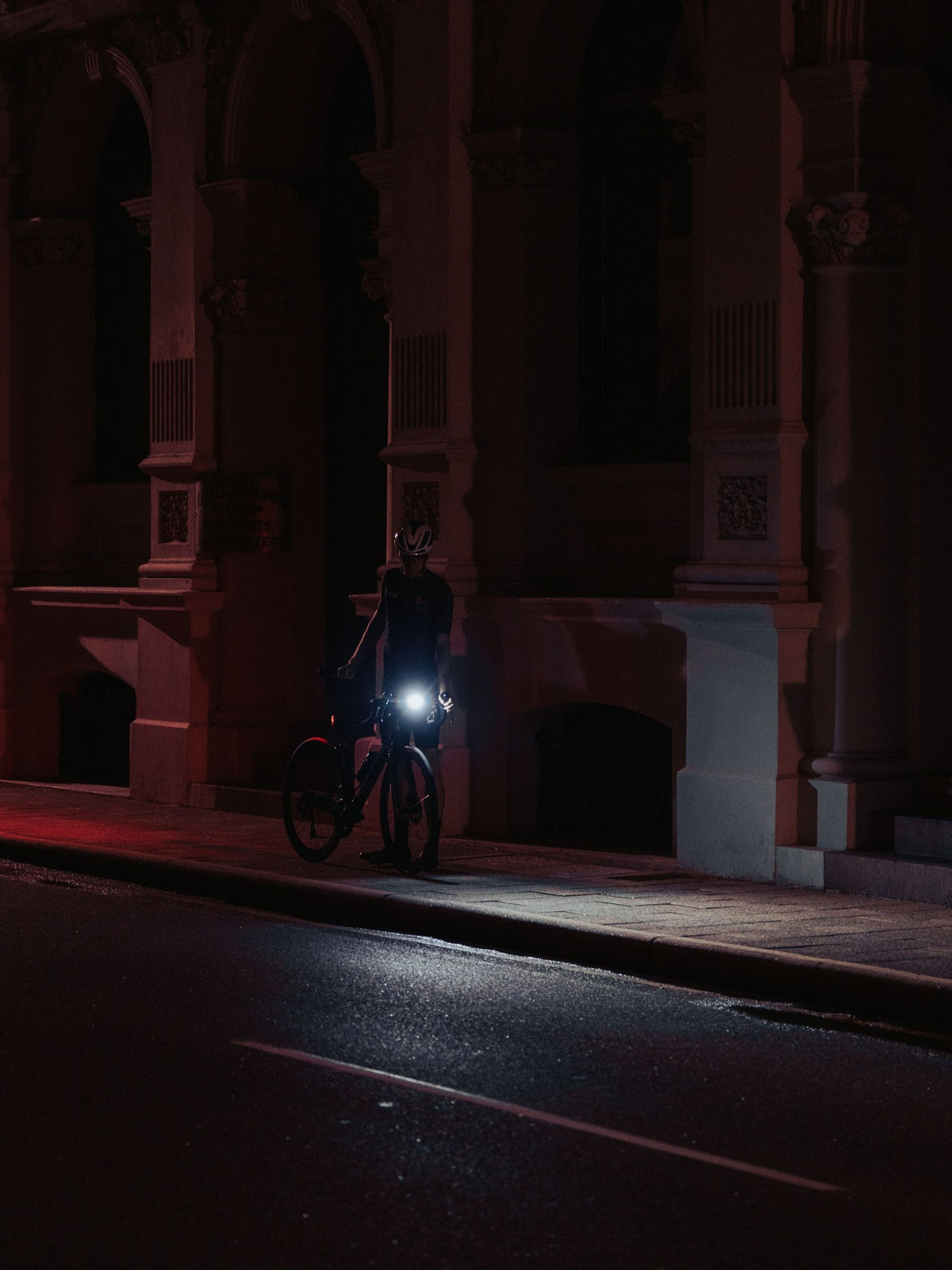 Cycliste en ville de nuit avec un éclairage avant Ravemen allumé
