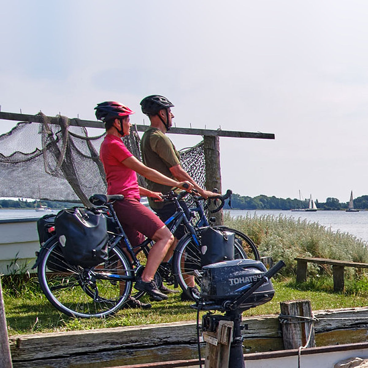 Couple de cyclistes équipés SIGMA à l'arrêt face à la mer